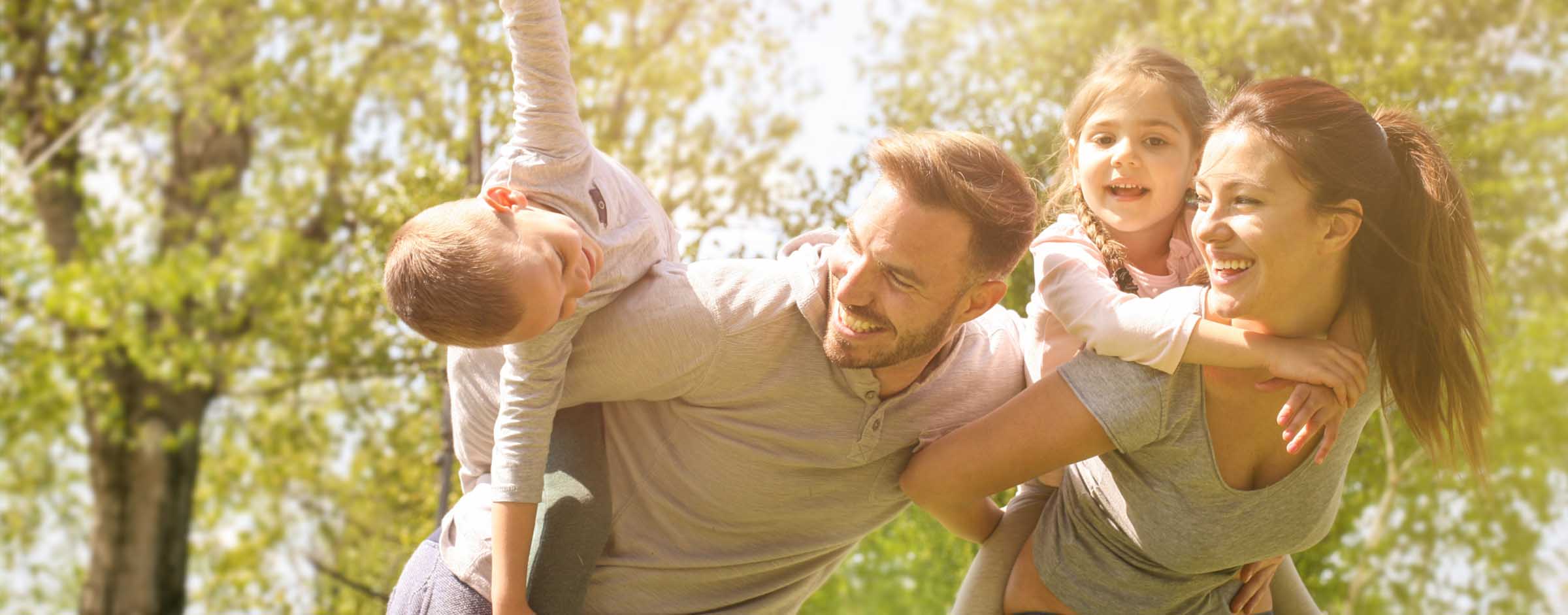 A joyful family of four plays outdoors - https://www.dmia.com/